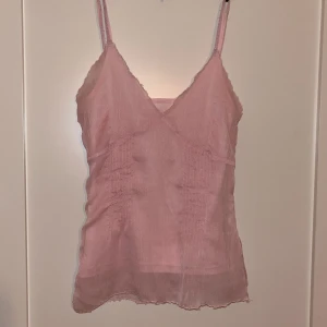 Rosa linnetopp från Eve of eden - Säljer en söt rosa linnetopp från Eve of Eden. Toppen har smala axelband och en lätt transparent look. Perfekt för varma dagar eller som ett lager under en tröja. Det står att tröjan är i storlek M men den passar snarare en S/XS💕