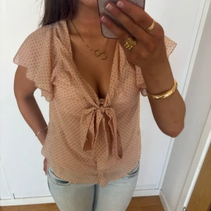 Prickig blus - Supersöt prickig topp med rosett volanger. Jag är 168 och det är mina bilder, köp via köp nu direkt eller Swish, kvar tills markerad som såld 💕