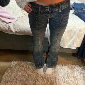 Blå jeans med bootcut och detaljer - Snygga mörkblå jeans med bootcut och låg midja plus sydda detaljer. Lite 2000-tals look. Använda 2-3 gånger.