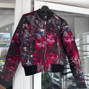 Färgglad bomberjacka  - Snygg bomberjacka från Jofama x Måns Zelmerlöw med ett färgstarkt abstrakt mönster. Rensar ur min garderob från en hel del kläder🌼 Om du ser något mer i min profil som du gillar så skickar jag med det till dig också!😊 Fler kläder kommer! 