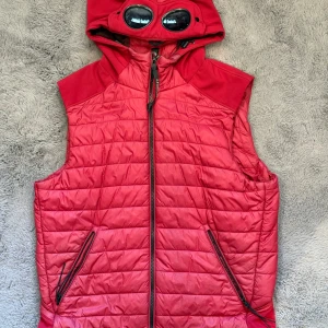 CP Company Väst - Säljer en riktigt snygg och sällsynt CP Company jacka i röd färg – storlek 50, motsvarar M/L. Passar perfekt för dig som är runt 180 cm. Jackan är köpt för några år sedan men är knappt använd och i mycket fint skick.  Modellen och färgen är svårt att få tag på idag, särskilt i detta skick.                                                  Jackan är perfekt för våren och sommaren tack vare sitt lätta material och stilrena look.