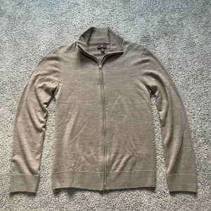 Beige full-zip från H&M i 100% merinoull - Säljer en stilren beige full-zip från H&M i 100% merinoull med dubbelt dragkedja framtill | Storlek: S | Använd ett fåtal gånger men inga defekter | Skick: 9,5/10 | Nypris: 500kr | Mitt pris: 239kr