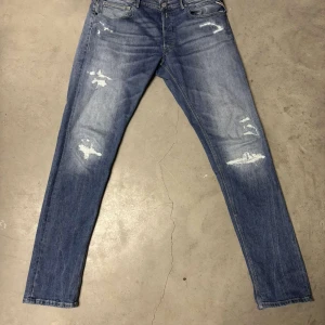Replay jeans - Snygga blåa replay jeans med feta slitningar. Modellen på jeansen är willbi i storlek 33/34. Modellen på byxorna liknar replay anbass modell och sitter därför slim. Vid frågor är de bara att kontakta mig!!😁