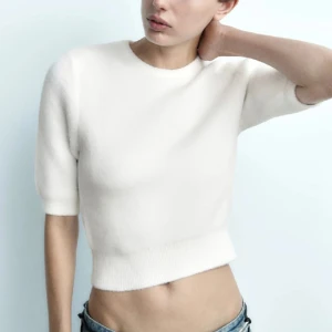 Vit tröja från Zara - Säljer en vit kortärmad stickad tröja från Zara. Tröjan har trekvartsärmar och är tillverkad i ett mjukt material. Perfekt för en avslappnad look. Säljer för att jag inte fått någon användning av den❤️