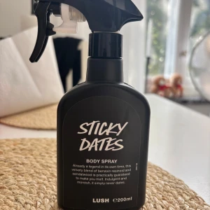 Sticky Dates Body Spray från Lush - Sticky Dates Body Spray från Lush i svart plastflaska med spraymunstycke. Doften är en söt och mysig blandning av benzoin, sandelträ och karamelltoner. Flaskan rymmer 200 ml och är vegansk samt självkonserverande. Använd minst 5 gånger bara!