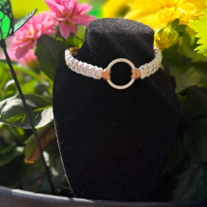 Handgjort vitt och guldfärgat armband sommar - 🌼✨ NYHET! Handgjort armband i vitt & guld ✨🌼  Låt sommaren pryda din handled! Det här stilrena armbandet är knutet för hand i vitt och guldfärgat band, med en elegant rund detalj i mitten som symboliserar balans och harmoni. 🌿  🔸 Ställbart – passar de flesta handleder 🔸 Unikt & handgjort 🔸 Perfekt till både vardag och fest  🌞 Bär det som ett statement eller kombinera med fler armband för en personlig stil!