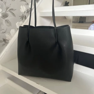 Väska - Säljer min snygga svarta läder väska då den inte har kommit till användning så mycket, köpt på åhléns för 499kr. Är som helt ny och är i nytt skick och passar perfekt till alla tillfällen.