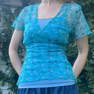 Söt topp - Åker bort i två veckor 29/6 så köp innan dess om du ej vill vänta🌸 Vintage meshtopp med knytning i ryggen som ger jättefin passform. Finns ingen storlek men skulle säga S, går att anpassa med knytningen. Jag har vanligtvis xs och är 162cm för referens. Hör av dig om du undrar något🩵