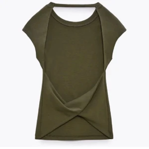 Olivgrön backless topp - Snygg olivgrön backless topp med korta ärmar. Den är perfekt för sommardagar eller en avslappnad utekväll. Toppen är i ett mjukt och stretchigt material som ger en bekväm passform och man känner inte dig strypt runt halsen