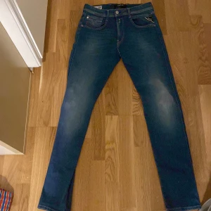 Replay jeans  - Snygga Replay Hyperflex jeans i mörkblå tvätt med klassiska fem fickor och vita sömmar bak. Modellen är skinny fit och tillverkad i stretchigt jeansmaterial med återvunna fibrer för extra komfort och rörelsefrihet. Perfekta för dig som gillar en tajt och modern look.