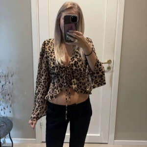 Leopardmönstrad blus från SHEIN - Säljer en croppad blus från SHEIN i storlek S med leopardmönster i beige och svart. Aldrig använd! Passar S och XS