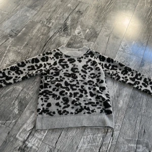 Grå leopardmönstrad stickad tröja Vero Moda - Säljer en grå stickad tröja från Vero Moda i storlek XS då jag inte kommer till användning. Fint skick och inga defekter 🤍