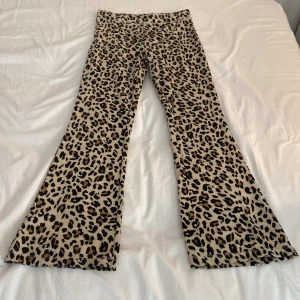 Leopardmönstrade bootcut-byxor  - Säljer ett par sjukt snygga bootcut-byxor med leopardmönster i beige, svart och brunt. Byxorna har en skön passform och är perfekta för dig som vill sticka ut med din stil. Materialet är mjukt och stretchigt, vilket gör dem riktigt bekväma.