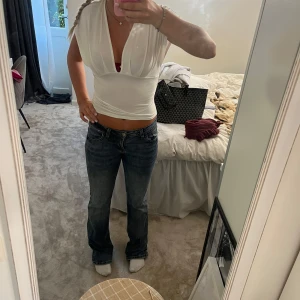 Blåa Lågmidjade jeans  bootcut  -  säljer ett par blåa låg midja det bot katt jeans som sitter jättebra på människor som är mellan 163 och 170 det är storlek 27 i midjan och 32 längd perfekta till skolan dessa är slutsålda i affär och online