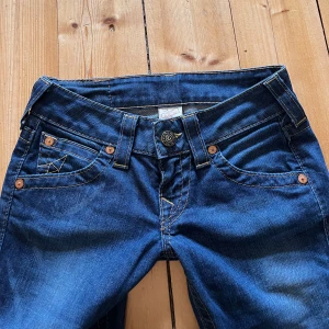 Vintage True Religion bootcut jeans  - Säljer ett par jättefina blå jeans från True Religion med bootcut passform. Jeansen är lågmidjade och i bra skick. Endast lite slitna längst ner på benen. Skriv gärna först om du är intresserad eller om du vill veta mått på jeansen🌸