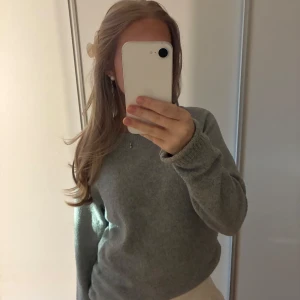 Grå stickad tröja - Mysig grå stickad tröja med rund hals och långa ärmar. Tröjan är knappt använd. Perfekt att matcha med kjol eller jeans. 
