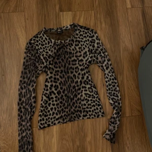 Leopardmönstrad långärmad tröja - Säljer en snygg långärmad tröja från Bik Bok med leopardmönster i bruna och svarta toner. Tröjan har rund hals och är figurnära i passformen Passar till jeans eller kjol 