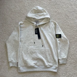 Stone Island Hoodie - En fin och helt ny oanvänd Stone Island Hoodie som är super bekväm. Passar perfekt för vinter vädret när det är kallt. Saljer den eftersom den var lite för stor för mig. Priset gar att diskutera. Skickas pà samma dag