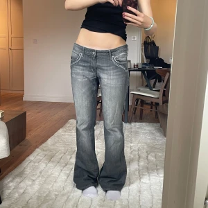 Grå bootcut jeans med låg midja - Säljer ett par grå jeans med bootcut passform och låg midja🫶🏼 Innebenslängden är 82cm och midjemåttet är 91cm! Jag är 171cm. 