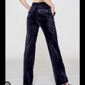 Mörkblå velourbyxor med snörning - Snygga mörkblå mjukisbyxor i mjuk velour med raka ben och bred resår i midjan. Byxorna har snörning framtill och stora fickor både fram och bak med coola detaljer. Perfekta för en chill och avslappnad stil.