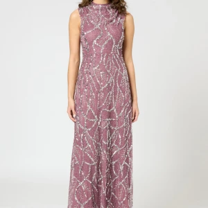 Lång lila paljettklänning med mönster - Säljer en magisk lila långklänning med glittriga paljetter och ett unikt mönster i silver. Klänningen är ärmlös med hög hals och har en slim passform som framhäver figuren. Perfekt för bal eller fest när du vill sticka ut och glänsa.   Köptes för exakt en månad sedan, använd en gång och är i storlek 40. Den sitter exakt som bilden köpt från zalando, ny kostar 3070 kr. 