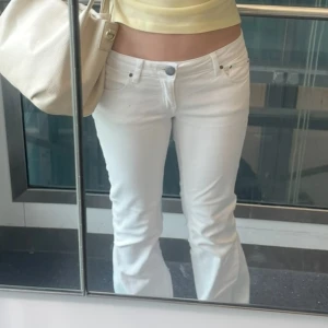 Vita låg midjade bootcut jeans från EDC - Säljer ett par vita jeans från EDC med bootcut passform och klassisk femficksdesign. Byxorna har låg midja, snygga bakfickor med broderi och är gjorda i mjuk bomull med lite stretch. Byxorna är sydda nertill 🩷