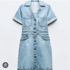 Kort jeansklänning från Zara - Säljer en ljusblå jeansklänning från Zara i storlek XS. Klänningen har korta ärmar, v-ringning, knappar hela vägen framtill och flera fickor både fram och bak. Snygg krage och uppvikta ärmslut ger en cool vibe. Perfekt för dig som gillar denim och vill ha en chill look.