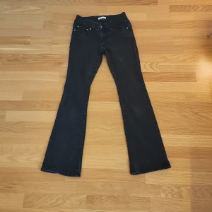 Bootcut svarta jeans från Gina Tricot - Svarta bootcut jeans från Gina Tricot, modell Perfect Jeans. Klassisk femficksdesign med silverfärgade knappar på bakfickorna. Jeansen har en snygg utsvängd passform och är tillverkade i mjukt denim-material. Passar snyggt till att vad som helst. Perfekt för dig som gillar en stilren look.