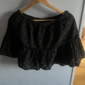 Svart volangkjol från Monki - Supersöt svart kortkjol från Monki i storlek S. Kjolen har broderade detaljer med små hålmönster och volangkant nertill. Den har en elastisk midja som gör den bekväm och lätt att bära. Originellt från monki men köpte på karlaplan loppisen, kan dock tänka mig att den även där va ganska ny pga prislappen som hänger kvar. Står storlek S men jag ansåg att den va lite för stor så hade säkert passat bra på m eller L, de är även anledningen till att jag säljer!!