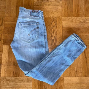 Dondup jeans - Snygga ljusblåa jeans från Dondup med diskreta slitningar. Modellen är slim och har raka ben med låg midja. Skicket på jeansen är bra men dem har en liten svart fläck på högra knät. Hör av dig om du har några frågor. 
