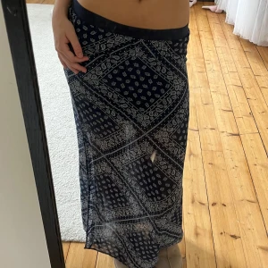 Mönstrad långkjol med slits från h&m Divided - Säljer en marinblå långkjol från hm Divided med vitt paisleymönster och en snygg slits på sidan. Är väldigt luftig och har ek miniskor under. 