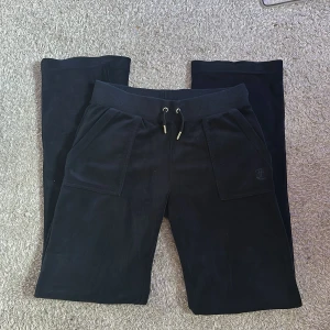 Mörkblå byxor Juicy Couture S - Mörkblå mjukisbyxor från Juicy Couture i mjuk velour med bred resår och snörning i midjan. Stora fickor fram och bak, bakfickorna har snygga knappar. Perfekta för en chill och trendig look.