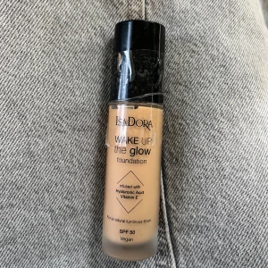 IsaDora Wake Up The Glow Foundation 5W - IsaDora Wake Up The Glow foundation i nyansen 5W. Ger en naturligt glowig finish och innehåller hyaluronsyra och vitamin E. SPF 50 och vegansk formula. Kommer i en smidig glasflaska med svart pump.
