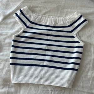Randig stickad linnetopp från Oysho - Superfin stickad crop top från Oysho i vitt med marinblå horisontella ränder. Toppen är ärmlös med bred ribbad kant vid hals och nederdel. Säljes då den känns för liten för mig (skulle säga xxs). Men annars älskar jag den, super mjuk, tight men skön! 