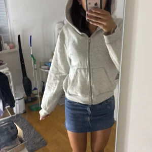 Ljusgrå hoodiejacka från 157, S - Ljusgrå hoodiejacka från 157 med dragkedja framtill och stora fickor. Mjuk och skön i bomullsmix, perfekt för chill dagar. Klassisk huva och ribbade muddar ger en avslappnad vibe. Passar dig som gillar enkel och clean stil.