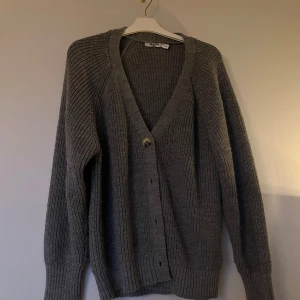 Grå stickad kofta från NA-KD - Mysig grå stickad kofta från NA-KD i storlek XS, men är mer av en S. Använt ganska mycket men har inga detaljer av användning! Den har inte nopprat sig alls, och sticks inte heller.