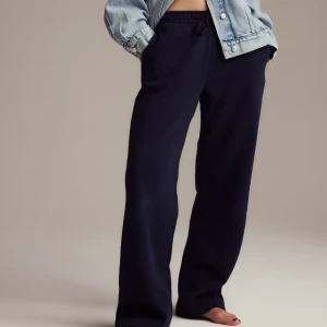 Marinblå mjukisbyxor med snörning - Marinblå mjukisbyxor med avslappnad passform och resår i midjan med snörning. Byxorna har raka ben och är tillverkade i ett mjukt material som känns skönt mot huden. Perfekta för chill dagar eller när du vill vara bekväm.