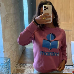 Isabel Marant sweatshirt  - Säljer en lila sweatshirt från Marant med stort blått och vitt logotryck framtill.  Så söt och skön! Älskar älskar älskar. Står storlek 38 på lappen men jag brukar ha xs/s och den passar superbra!💕 Så beror på hur man vill ha passformen 