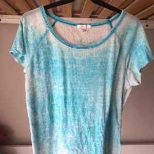 Turkosvit t-shirt från Delias - T-shirt i turkos och vitt från Delias. Mönstret är melerat och materialet är mjukt, tunt och luftigt. Storlek M.