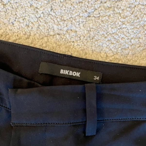 Svarta kostymbyxor från BikBok - Svarta kostymbyxor från BikBok i bootcut. De är low waist och i mycket bra skick