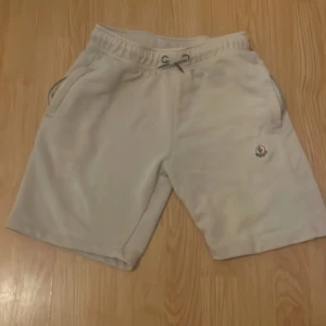 Beige shorts från Moncler med snörning - Snygga beige shorts från Moncler med klassisk logga på benet. Mjukt material, elastisk midja med snörning och två sidofickor. Perfekta för chill dagar eller när du vill ha en clean look.