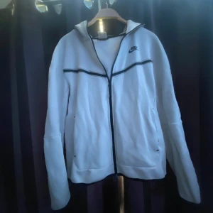 Vit Nike tech - Säljer denna Nike tech.knappt använt i riktigt bra skick. Perfekt för en sportig och avslappnad stil.