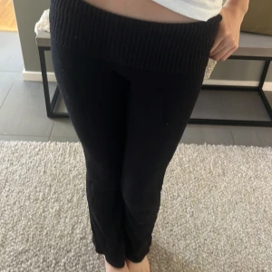 Svarta stickade mjukisbyxor - Mysiga svarta mjukisbyxor med bred ribbad midja. Byxorna är stickade och har en relaxed passform, perfekta för chill dagar hemma. Midjan är hög och elastisk för extra komfort.