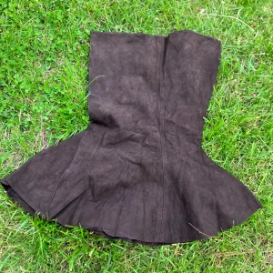 Struthätta i skinn - Säljer en  brun struthätta  i skinn. Den är helt utan mönster eller detaljer. Den är inte helt jämnt klippt / inte fållad så det finns ojämnheter.