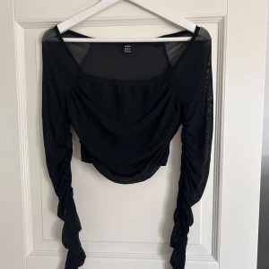 Svart topp - Aldrig använd. Nät ärmar. 