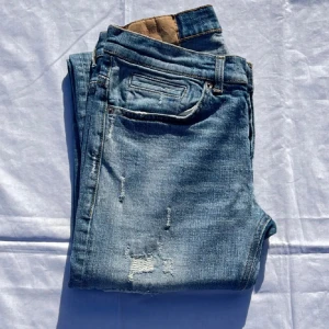 Dondup George - Säljer nu dessa feta blåa Dondup George jeans med sjukt snygga slitningar. Skicket på dessa är 9/10 utan några slitningar. Storleken på dessa är w31. Midja 37cm lår 22cm ytterlängd 100cm innerlängd 77cm. Ifall du har några frågor är det bara att höra av sig 