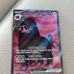 Oinkologne ex - Cool och glittrig Pokémonkort med Oinkologne ex! Med attacker som Maddening Scent och Heavy Stomp är detta kort perfekt för dig som vill stärka din samling eller ta ditt spel till nästa nivå. Perfekt för unga samlare och Pokémon-fans!