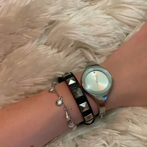 Valentino-liknande armband - Snyggt svart armband i skinnimitation med silvriga nitar. Väldigt lik valentino-armbandet och omöjligt att se skillnad från håll. Justerbart spänne som funkar perfa. Armbandet är helt nytt och endast testat. Säljer för det inte riktigt passar min stil. 