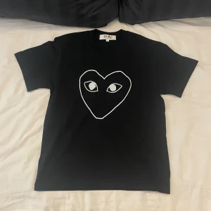 Comme des Garçons T-shirt  - En riktig snygg T-shirt från Comme des Garçons. | Den passar som en vanlig T-shirt. Och personen på bilden är 170cm så den passar om man är där omkring i längden. | Det är bara att höra av sig om man har några frågor eller vill ha flera bilder🌄🌄🌄