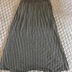 Svartvit långkjol från b.young - Långkjol från b.young i svartvitt grafiskt mönster. Kjolen har elastisk midja och är lätt utställd för en skön passform. Perfekt för dig som gillar stilrena och coola prints. Materialet känns mjukt och följsamt mot huden.